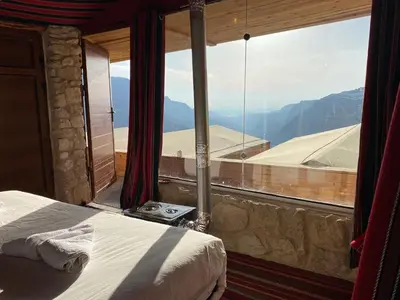 a bedroom with a large window with a mountain view at Dana Trail Cottages in Dana