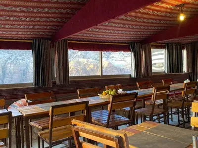 a dining room with tables and chairs and windows at Dana Trail Cottages in Dana