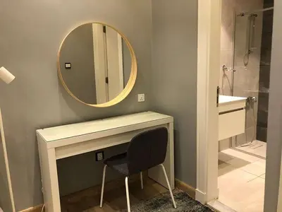 a bathroom with a mirror and a sink and a chair at luxury apartment in boulevard in Amman
