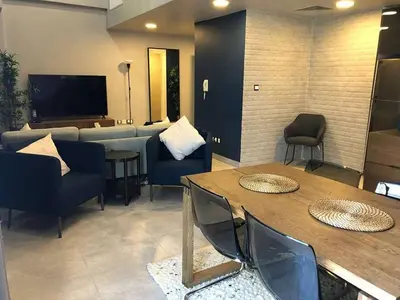 a living room with a couch and a table and chairs at luxury apartment in boulevard in Amman
