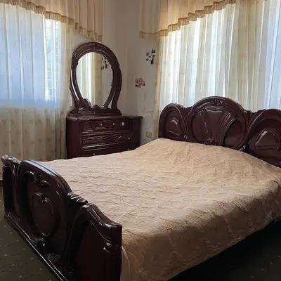 a bedroom with a bed and a dresser and a mirror at Ajloun Rest House in ‘Ayn Jannā