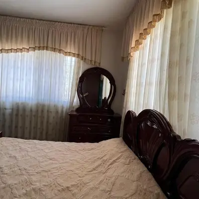 a bedroom with a bed and a dresser and a mirror at Ajloun Rest House in ‘Ayn Jannā