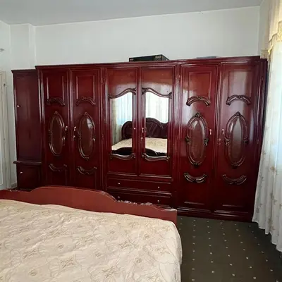 a bedroom with a large wooden cabinet with a bed at Ajloun Rest House in ‘Ayn Jannā