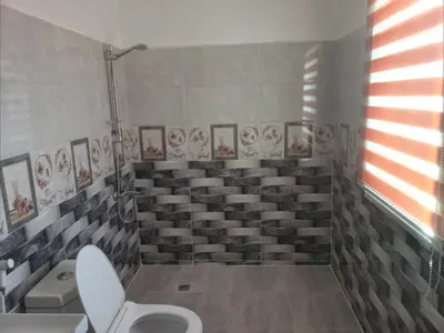 a bathroom with a toilet and a bunch of seats at بوابة جرش الرومانيه الشماليه in Jerash