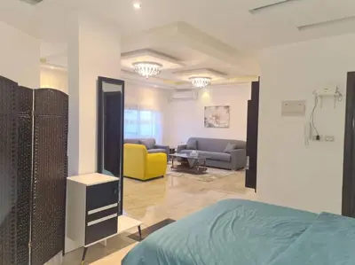 a room with a bed and a living room with a couch at Khalda Rooftop Apt. in Amman