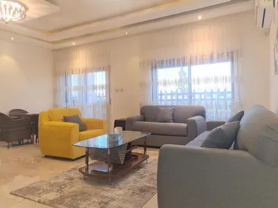 a living room with couches and chairs and a table at Khalda Rooftop Apt. in Amman