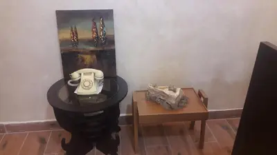 a table with a phone on it and a painting at Mesha Stele Private Hotel in Madaba