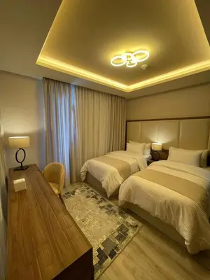 a hotel room with two beds and a table at Jeddah Homes Boutique Hotel in Amman