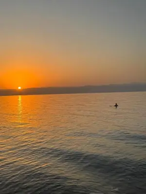 a person in a paddle board in the water at sunset at Apartment at Samarah Dead Sea Resort APT D-09 in Sowayma