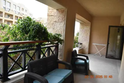 a balcony with a couch and chairs on a balcony at Apartment at Samarah Dead Sea Resort APT D-09 in Sowayma
