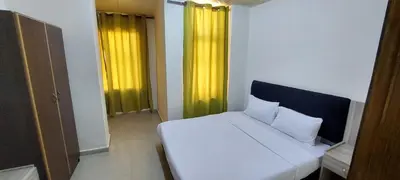 a white bed in a room with yellow curtains at Venice in Aqaba