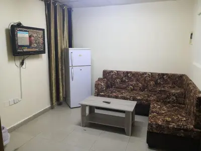 a living room with a couch and a table and a refrigerator at Venice in Aqaba