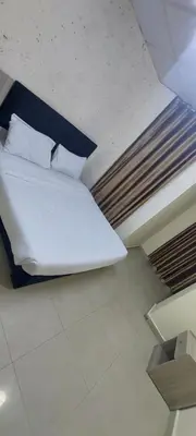 a bed with white sheets and pillows in a room at Venice in Aqaba