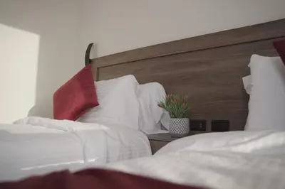 a bedroom with two beds and a wooden headboard at Petra Passion Inn in Taiyiba