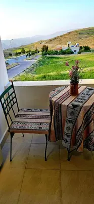a table and a bench with a table and a window at Petra Passion Inn in Taiyiba