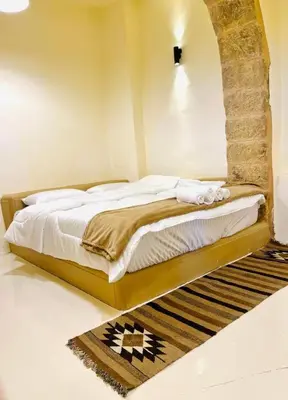 a bedroom with a bed in a room with a rug at Tafileh-Sila'a Heritage Village in At-Tafilah