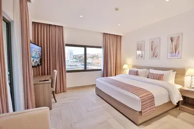 a bedroom with a large white bed and a window at Lavanda Boutique Suites Tala Bay in Aqaba