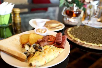 a plate of food on a table with pizza at Lavanda Boutique Suites Tala Bay in Aqaba