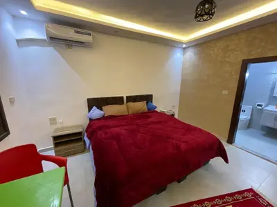 a bedroom with a red bed and a red chair at Black IRIS in Jerash