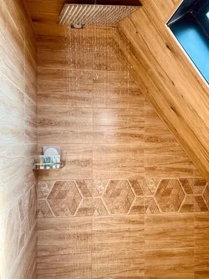 a shower with a wooden ceiling with a shower head at Deadsea OCTAGON in Madaba