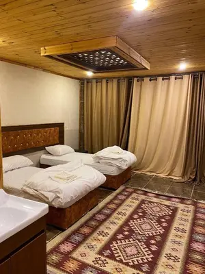 a bedroom with two beds and a sink and a rug at Full moon camp in Wadi Rum