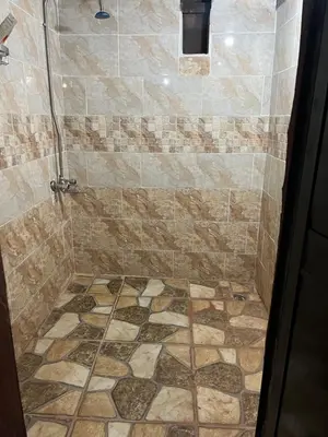 a bathroom with a shower with a stone floor at Wadi Rum Best Tours in Wadi Rum