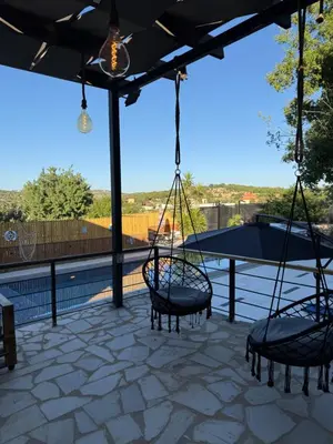 two swings on a patio with a view at Oak Farm Ajloun مزرعة البلوط عجلون in Ajloun