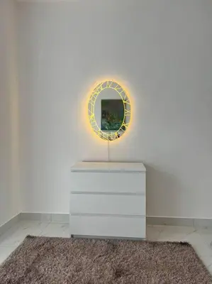 a white dresser with a mirror on a white wall at Modern studio in the heart of Amman in Amman