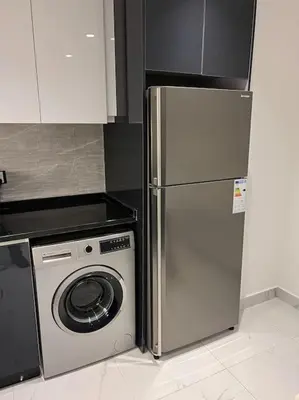 a kitchen with a refrigerator and a washing machine at Modern studio in the heart of Amman in Amman