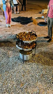 a group of food in pans on a beach at Lulua luxury camp in Wadi Rum