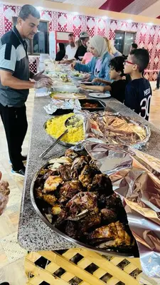 a buffet line of food with people standing around it at Lulua luxury camp in Wadi Rum
