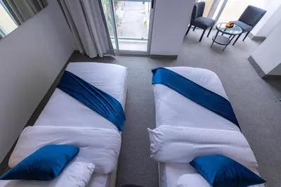 two beds in a room with blue and white pillows at Boho Boutique Hotel Amman in Amman