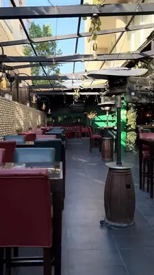 an empty restaurant with tables and chairs and a roof at Boho Boutique Hotel Amman in Amman