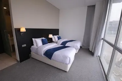 two beds in a hotel room with a window at Boho Boutique Hotel Amman in Amman