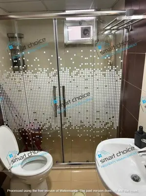 a bathroom with a glass shower with a toilet at fancy apartment gardens st 410 in Umm Uthainah