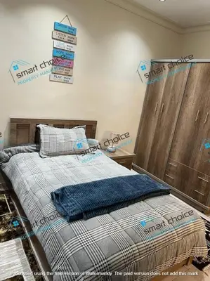 a bedroom with a bed with a sign on the wall at fancy apartment gardens st 410 in Umm Uthainah