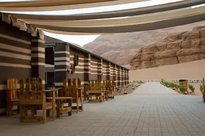 a patio with tables and chairs and a mountain at Desert Season Luxury Camp Wadi Rum Boutique Tents & Stargazing in Wadi Rum