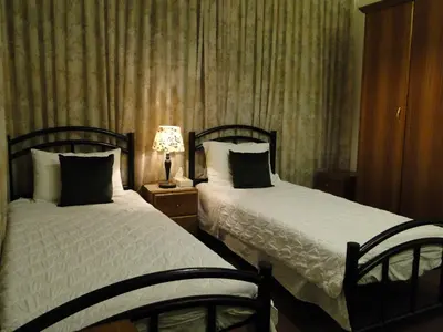 a bedroom with two beds and a lamp on a table at ( b&b ) Gadara rent room in Um Qeis