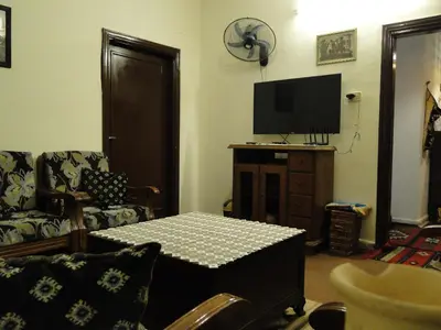 a living room with a table and a tv at ( b&b ) Gadara rent room in Um Qeis