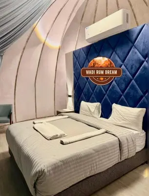 a bed in a room with a sign that reads war inn dream at RUM DREAM BUBBLES lUXURY CAMP in Wadi Rum