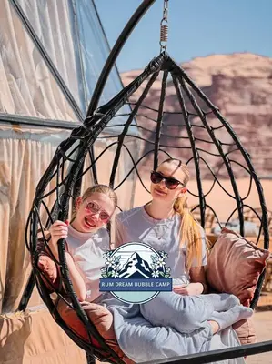 two girls are sitting in a swing at RUM DREAM BUBBLES lUXURY CAMP in Wadi Rum