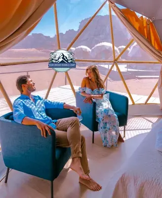 a man and woman sitting in chairs in a tent at RUM DREAM BUBBLES lUXURY CAMP in Wadi Rum