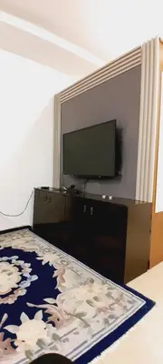 a bedroom with a flat screen tv and a bed at MK1 - Studio Stay in Amman