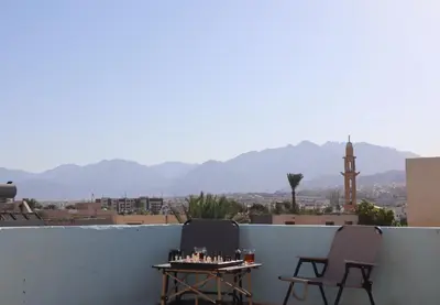 two chairs and a table on a balcony with a view at Extra Traveller in Aqaba