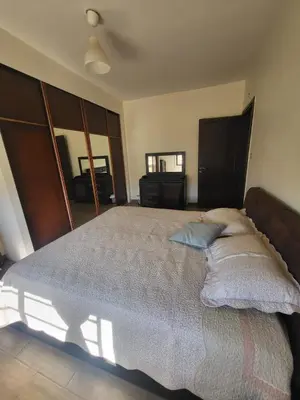 a bedroom with a bed with a blue pillow on it at MK6 - Two bedroom Apartment in Amman