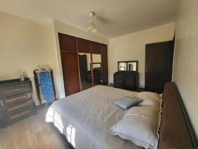 a bedroom with a large bed and a dresser at MK6 - Two bedroom Apartment in Amman