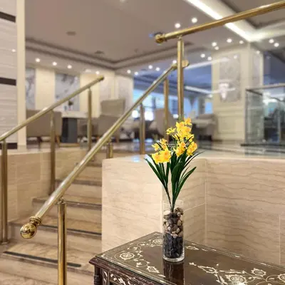 a vase with yellow flowers sitting on a table at Amman Paradise Hotel in Amman