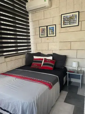 a bed in a room with a brick wall at Darna Hostel in Amman