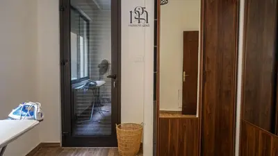 a room with a door with a person standing in a room at Maison Gaia, A Stylish Apartment in the heart of Amman in Amman