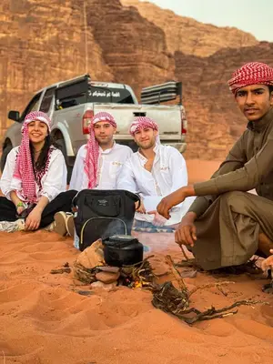 a group of people sitting around a campfire at Magic Bedouin Star in Wadi Rum